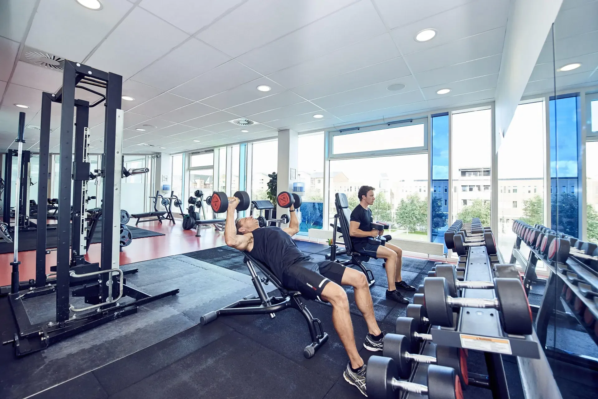 Gæster træner med håndvægte i hotellets fitnesscenter