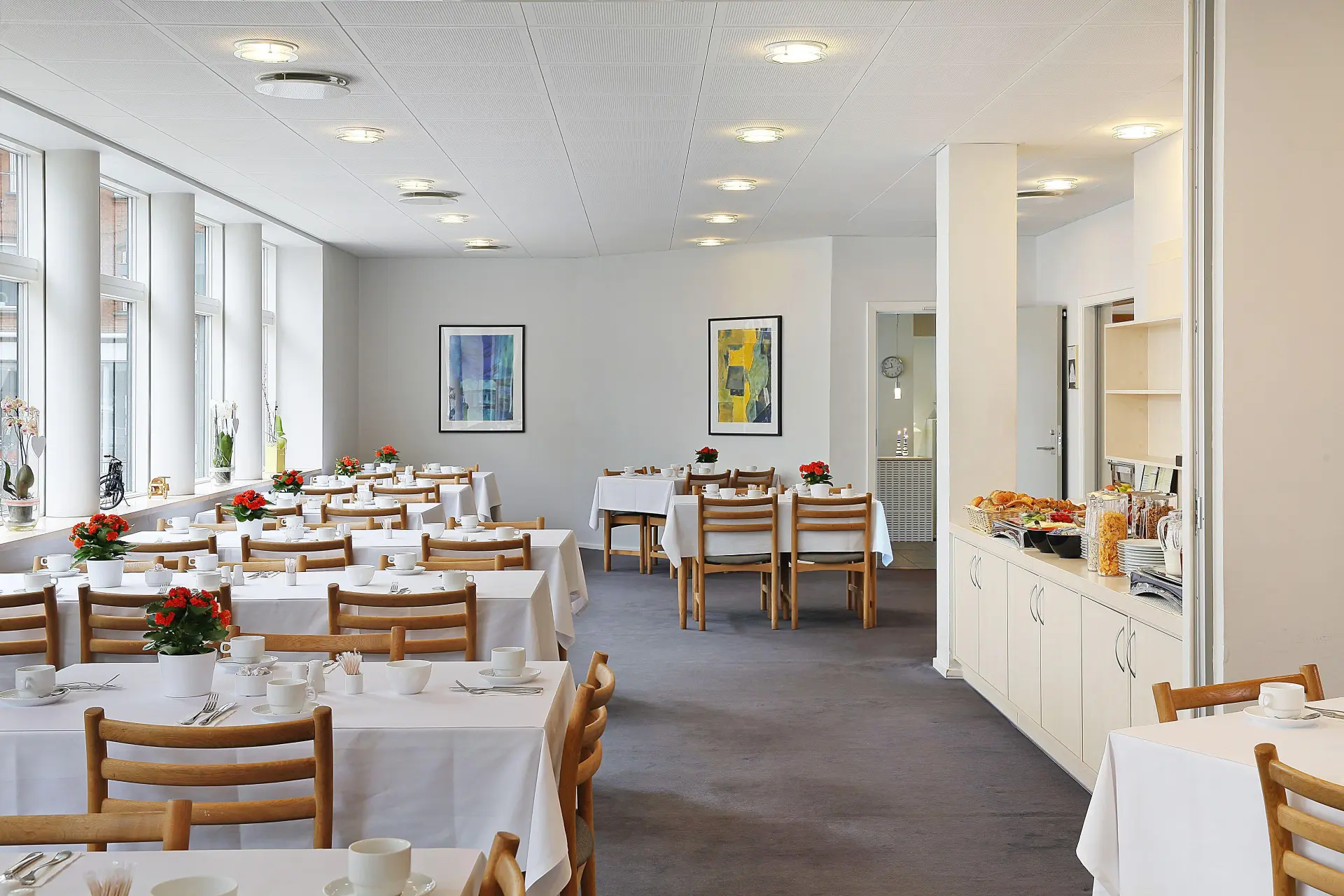 Lys morgenmadsrestaurant med dækkede borde
