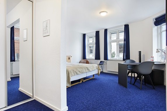 Juniorsuite set fra entréen med skrivebord og seng