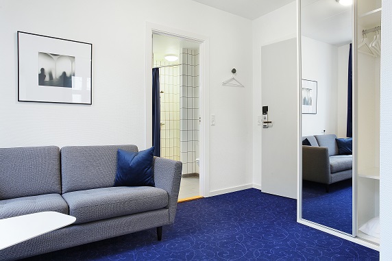 Juniorsuite med skrivebord, lænestol og udsigt over byen